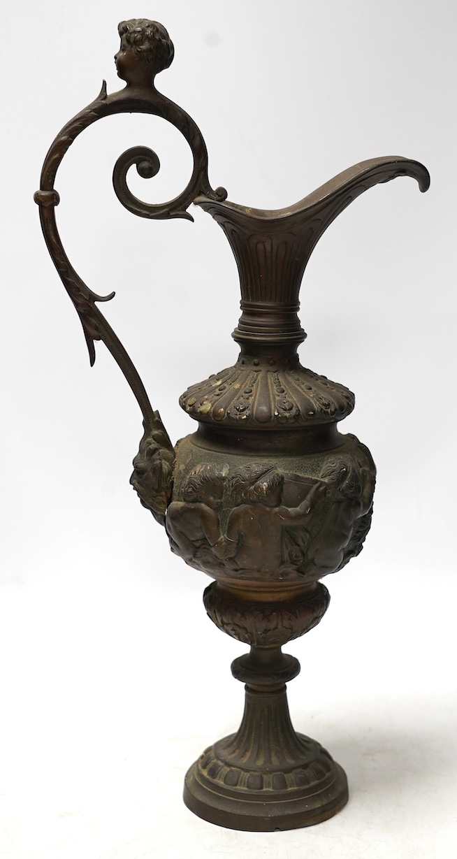 A Cellini style bronze ewer, possibly converted to a lamp later, decorated with putti panel and head handle, 42cm high. Condition - fair to good